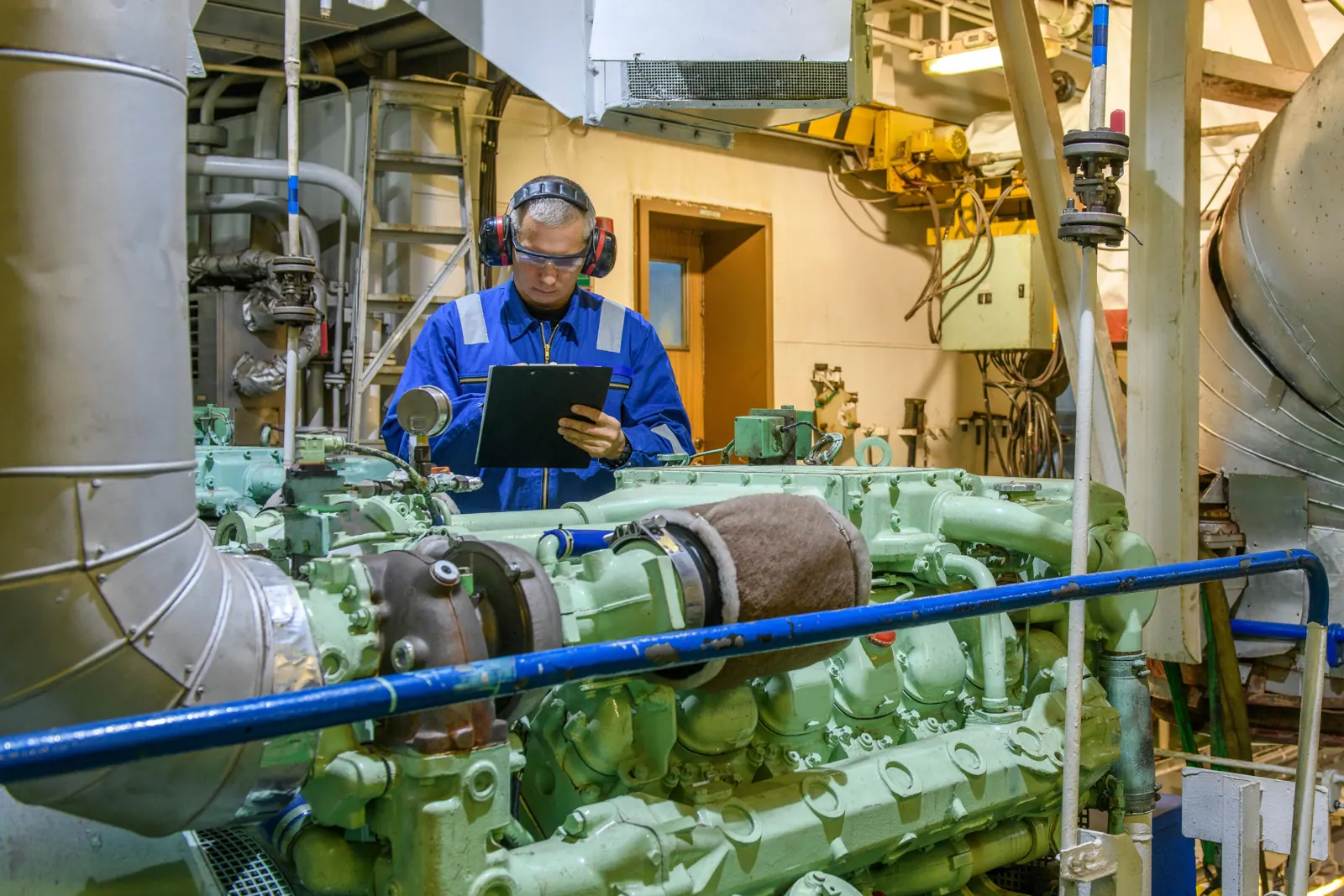 Engineer checking machinery in an engine room