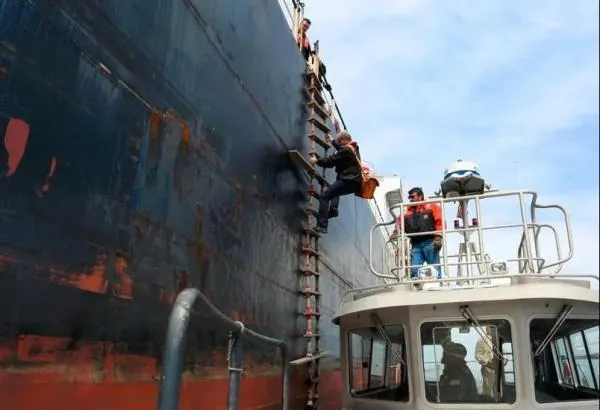 Pilot climbing a pilot ladder